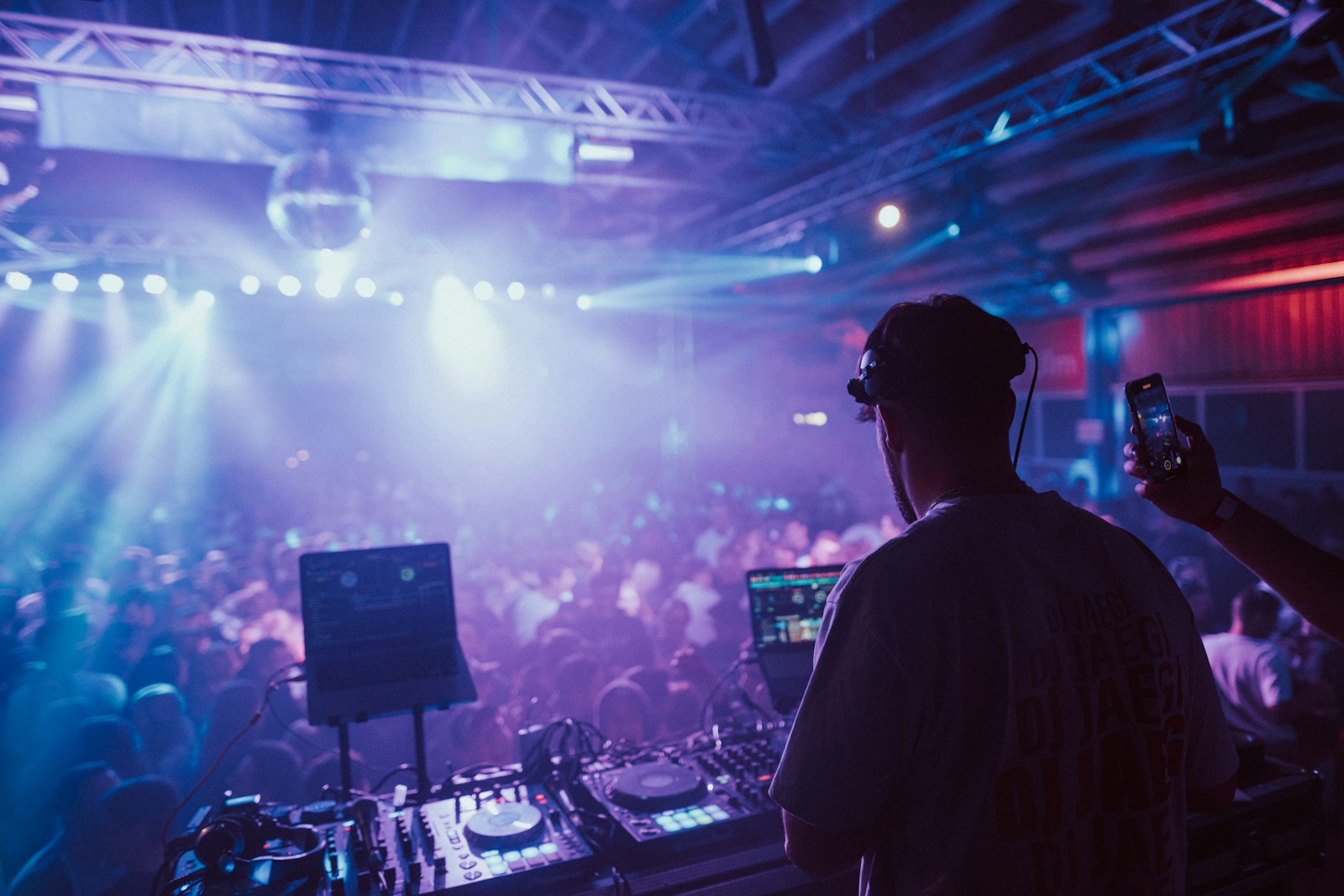 a man wearing headphones and holding a camera in front of a large crowd